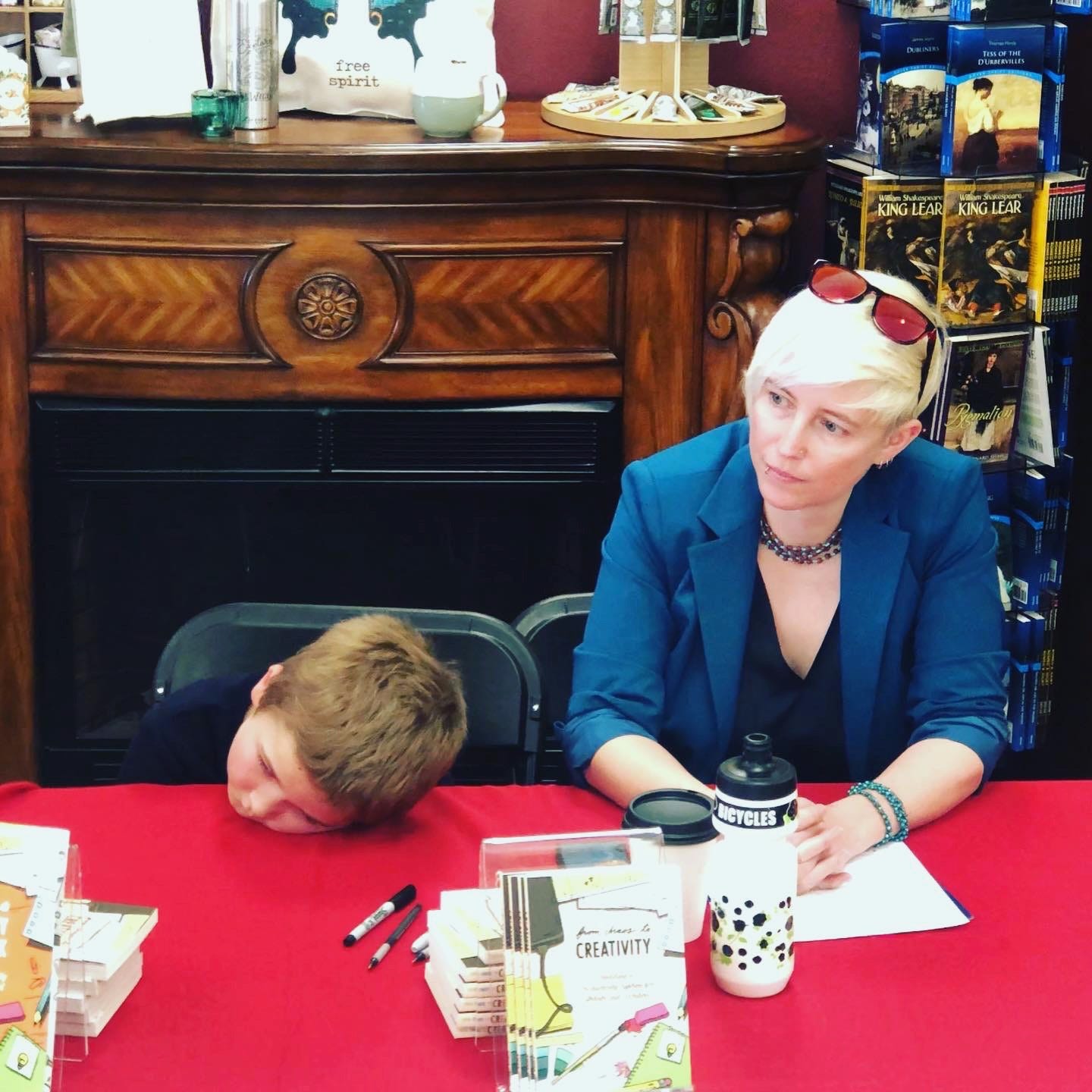 Jessie at a bookstore leading a workshop while her nephew is bored out of his mind beside her