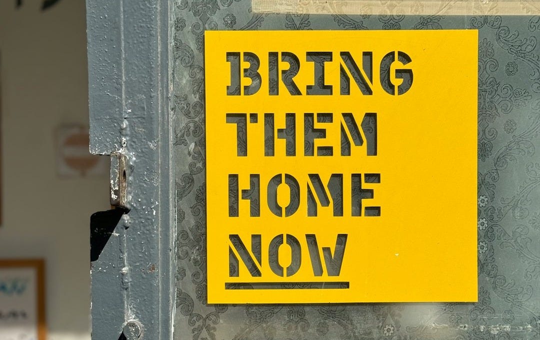 A yellow sign that says bring them home now A yellow sign that says bring them home now