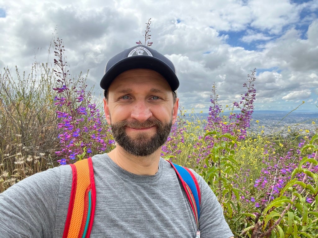 A person taking a selfie in front of purple flowers

Description automatically generated with medium confidence