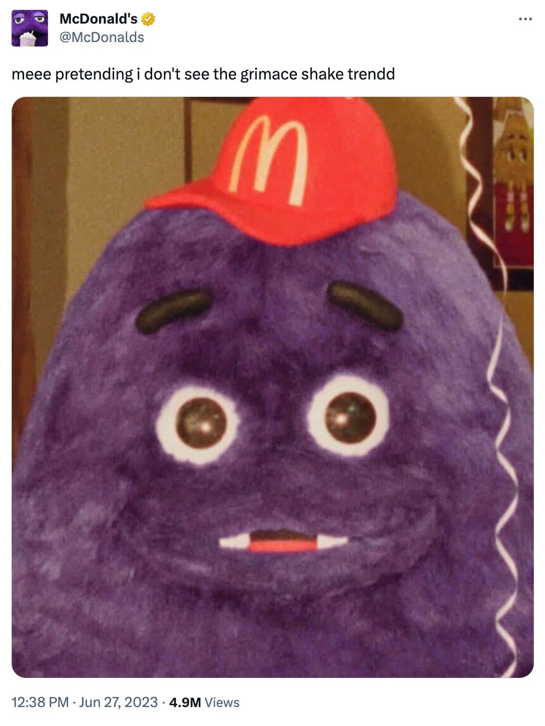 McDonald's tweet featuring Grimace with a red McDonalds hat. The Tweet says "me pretending i dont see the grimace shake trend