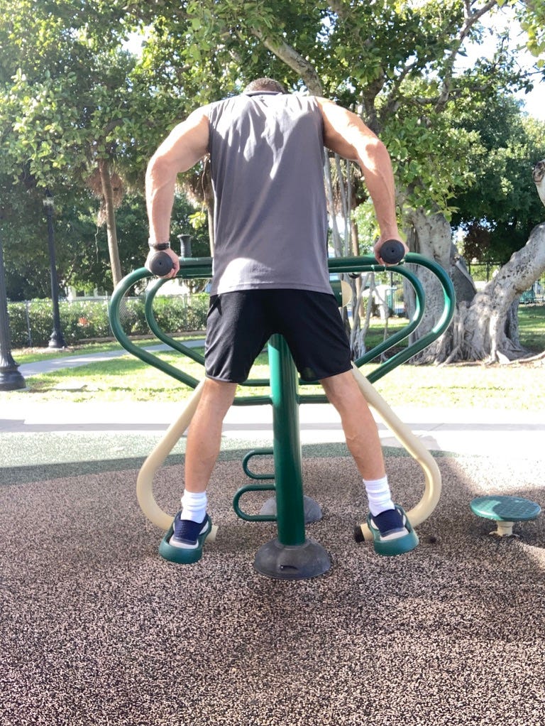 A person exercising on a playground

Description automatically generated