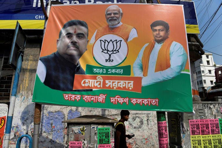 A man walks under a banner of India's ruling BJP outside the party's state office in Kolkata
