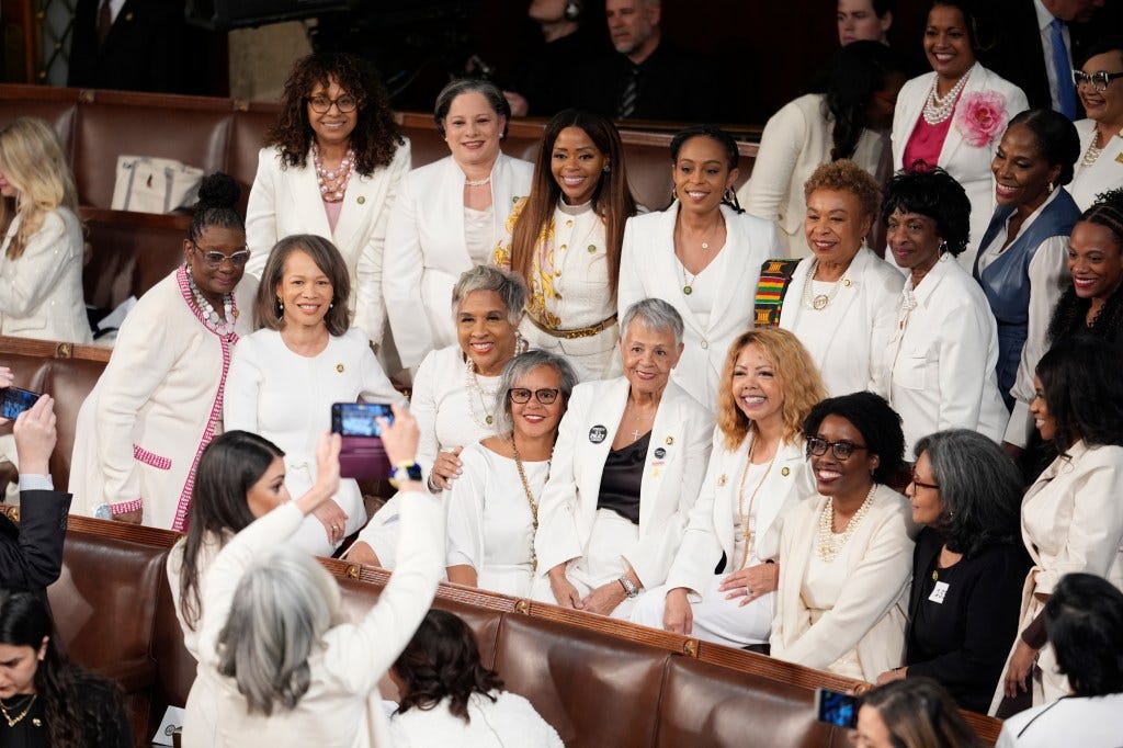Women members of the House of Representatives, pose for photos before President Joe Biden arrives to deliver his State of the Union address to a joint session of Congress, at the Capitol in Washington