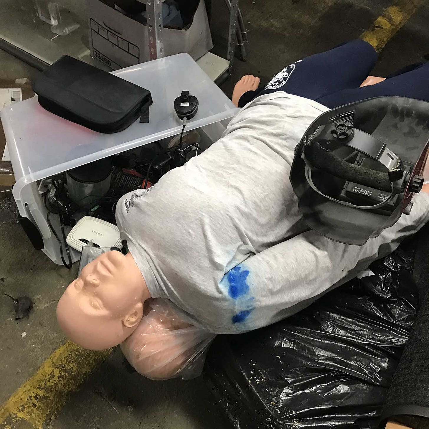 A photo of a dummy used for CPR training on the floor of a vacant medical testing facility