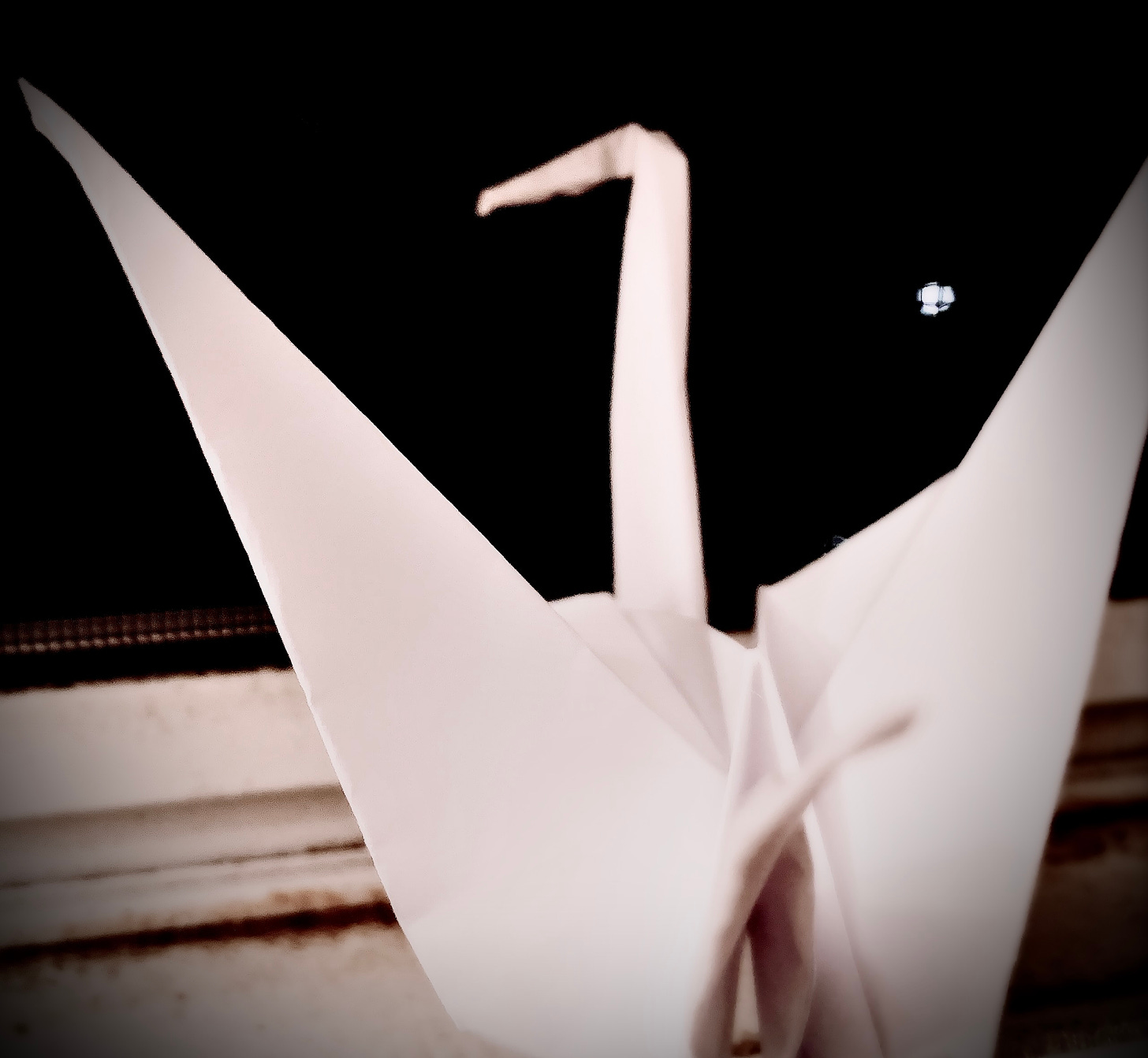 A picture of an origami crane (my first, don't judge) on my windowsill.