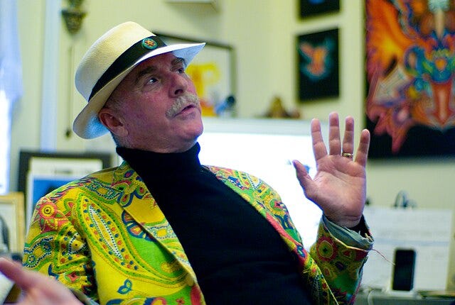 Profile photo of Howard Rheingold wearing a trademark brightly coloured jacket and panama hat.
