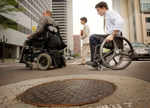 Civil rights lawyer Kevin Williams, left, leads paralympic athlete Scot Hollonbeck, right, away from federal court in Denver on July 28, 2003. Williams and other attorneys had filed a lawsuit against the U.S. Olympic Committee claiming discrimination under the Americans with Disabilities Act and the Rehabilitation Act. (Denver Post file photo) 