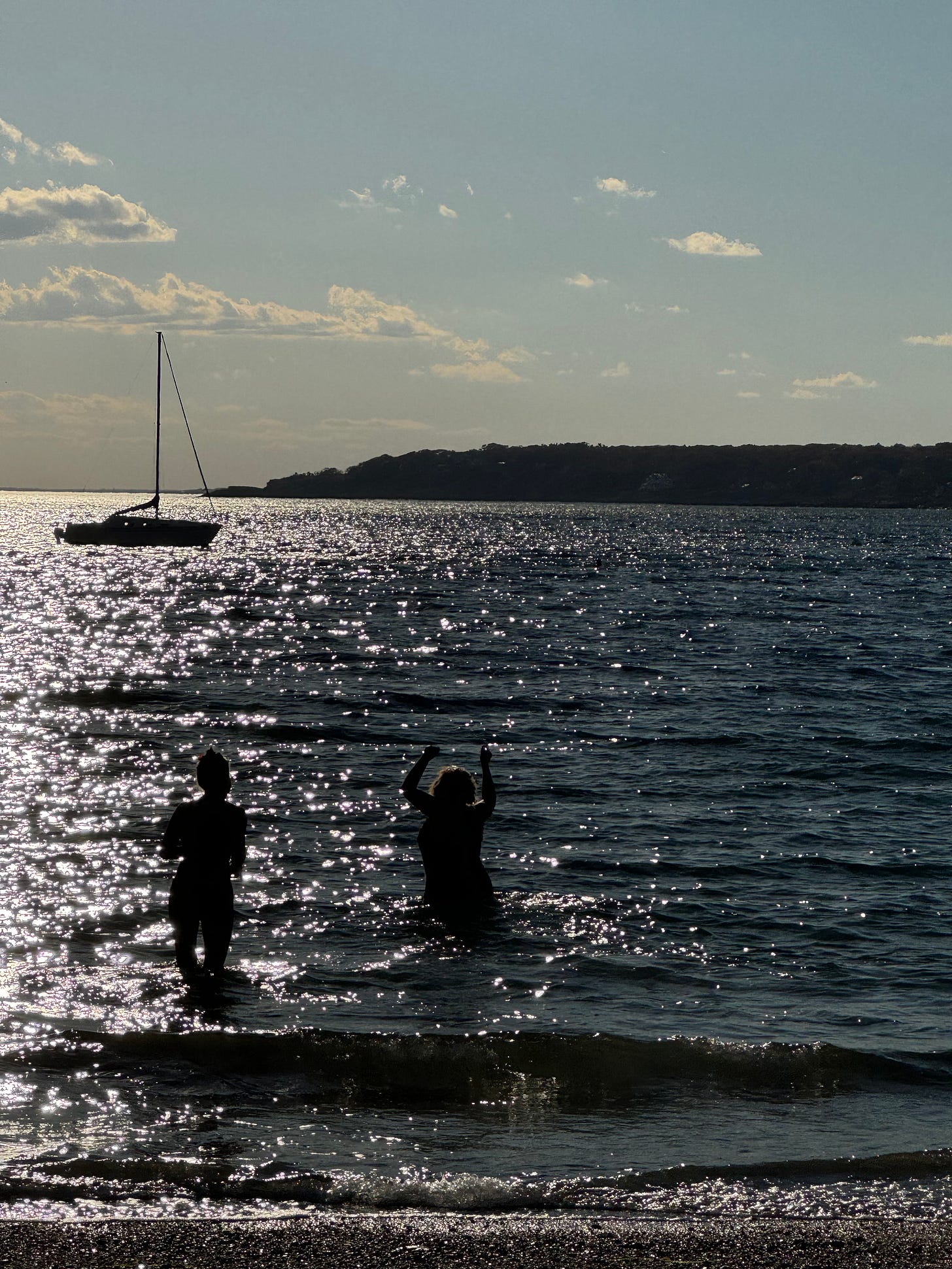 Phoebe in the ocean at sunset.