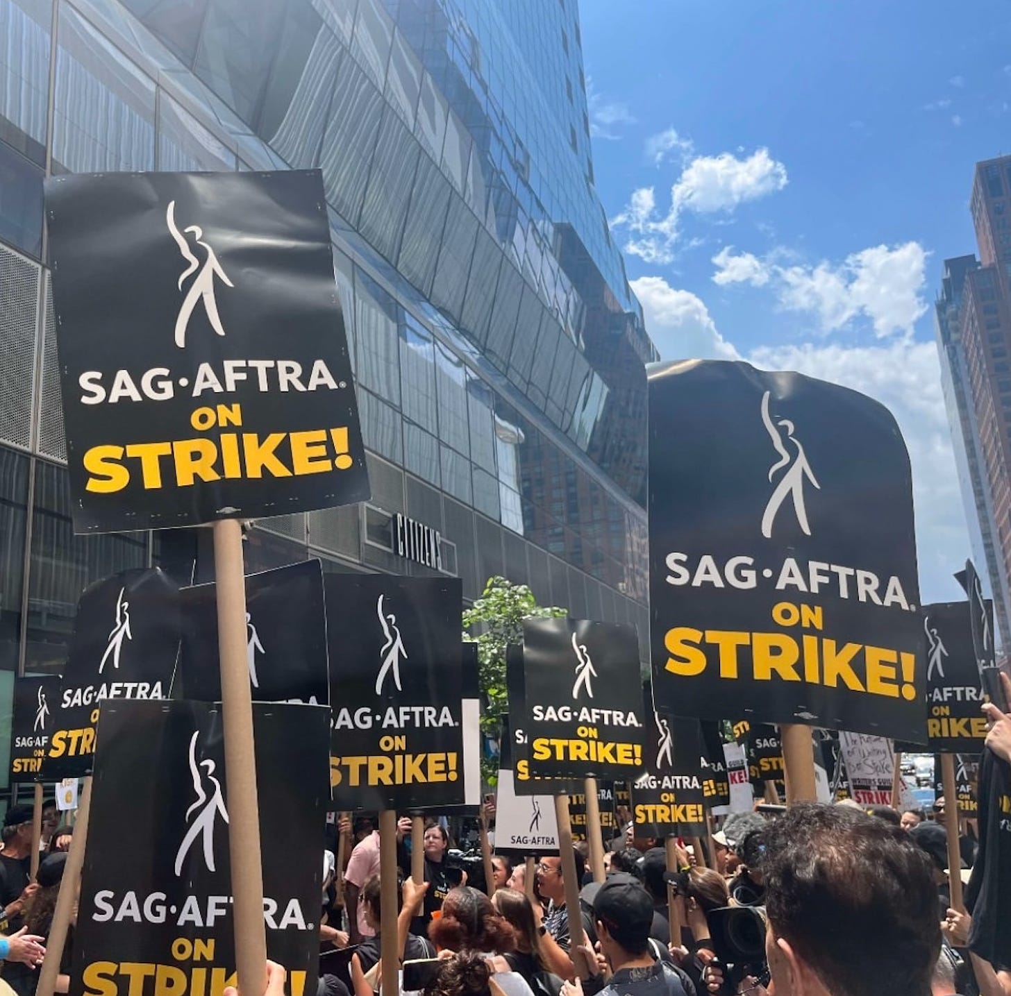 A large group of picketers holding "SAG-AFTRA ON STRIKE" signs.