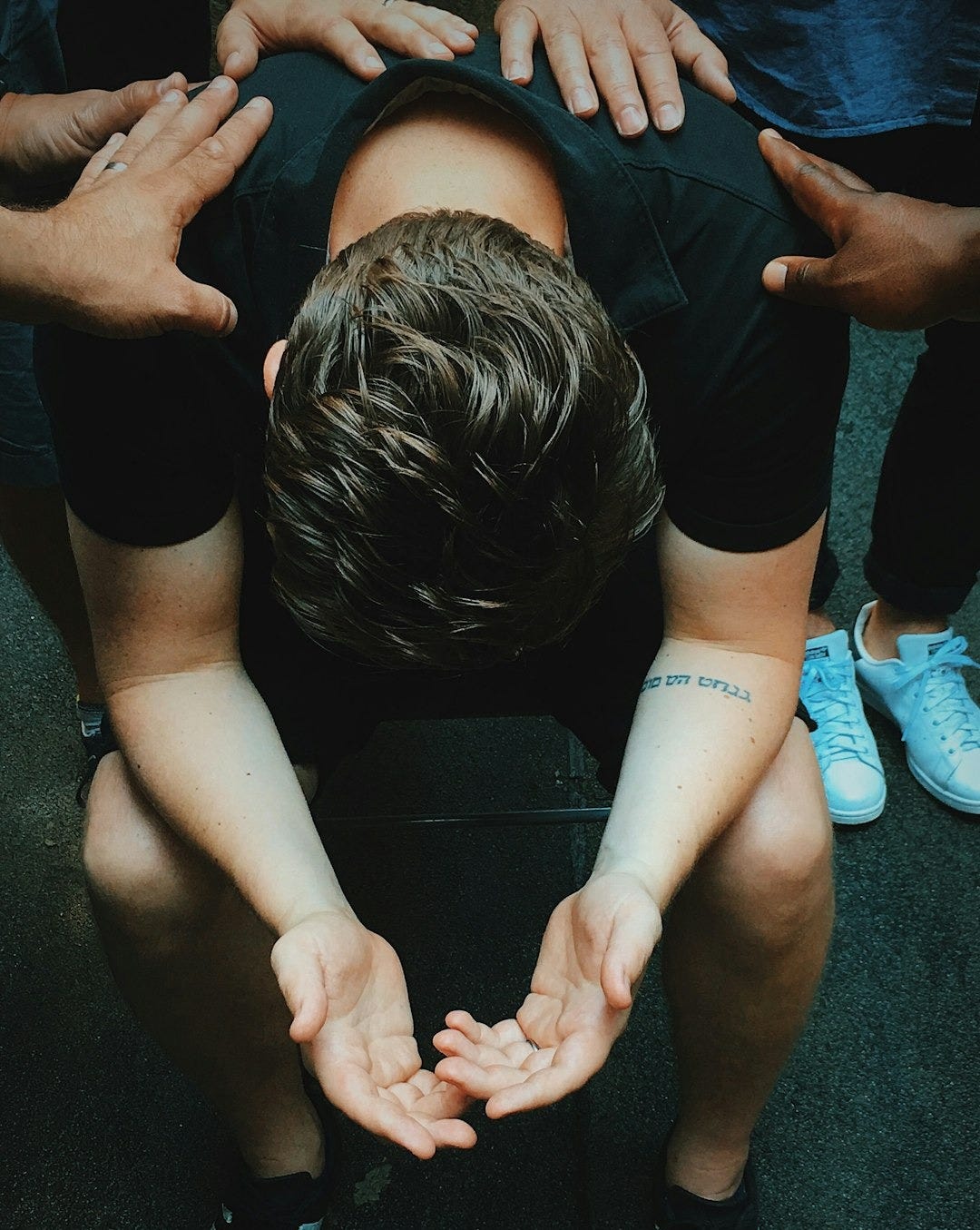 man sitting on chair holding and surrounded by people