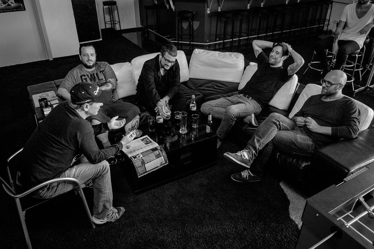 The author sitting on a couch with 3 musicians and a label owner, negotiating a record deal