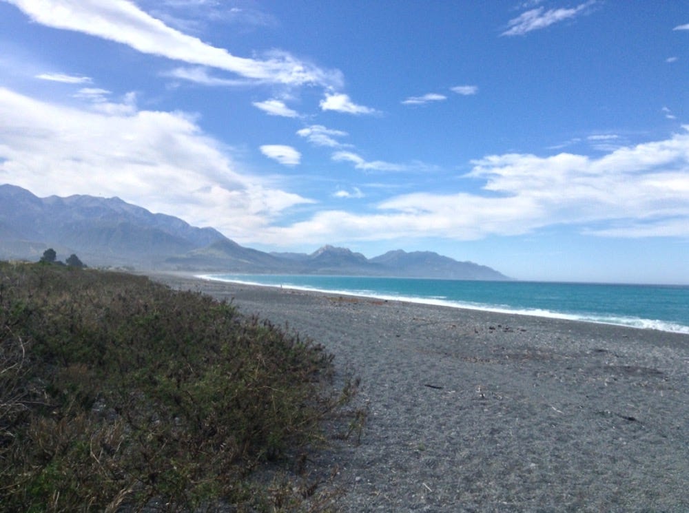 A view of the beach, blue sea and mountains in Kaikoura