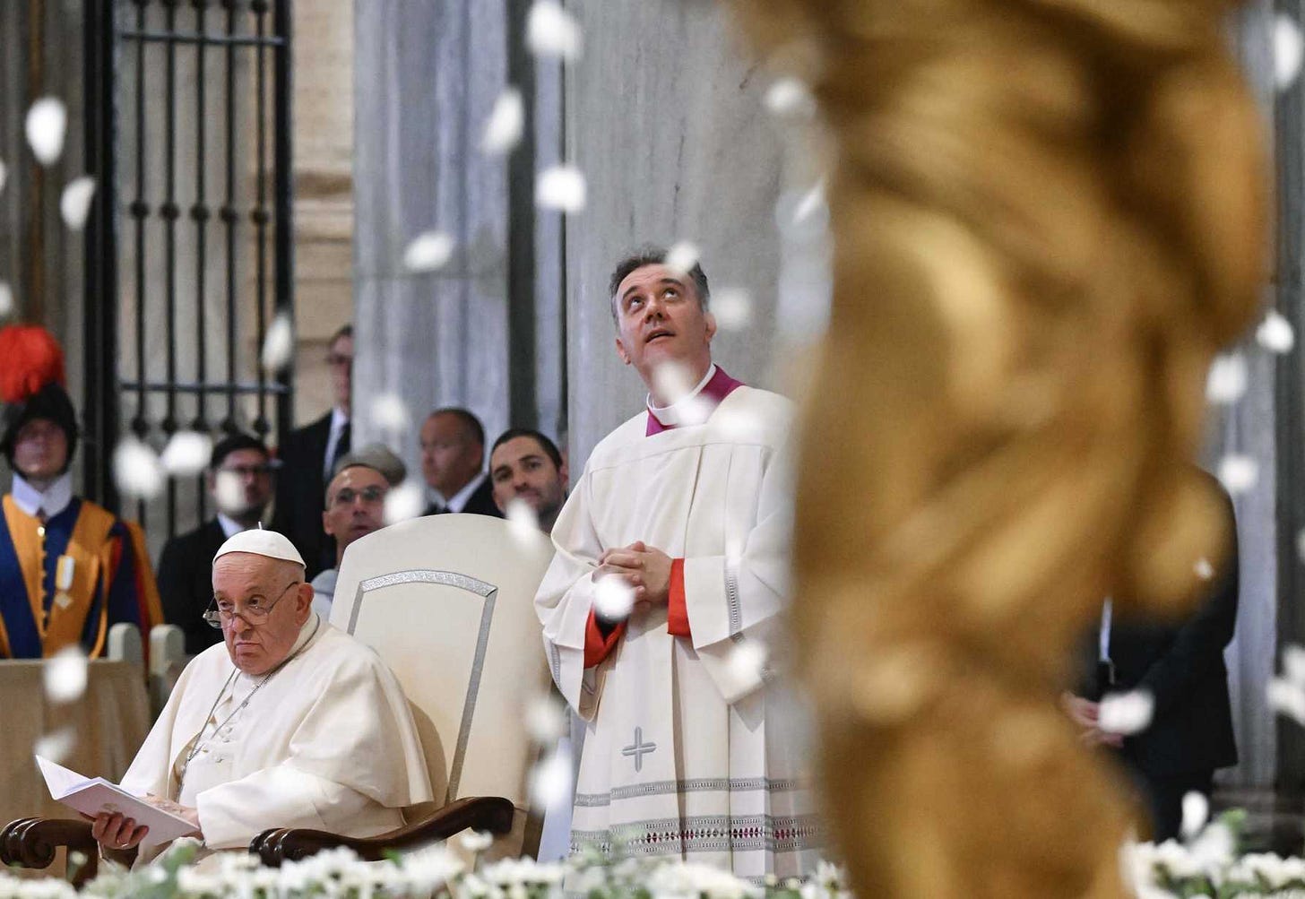 The Pope looking unimpressed as fake snowflakes fall inside a Basilica