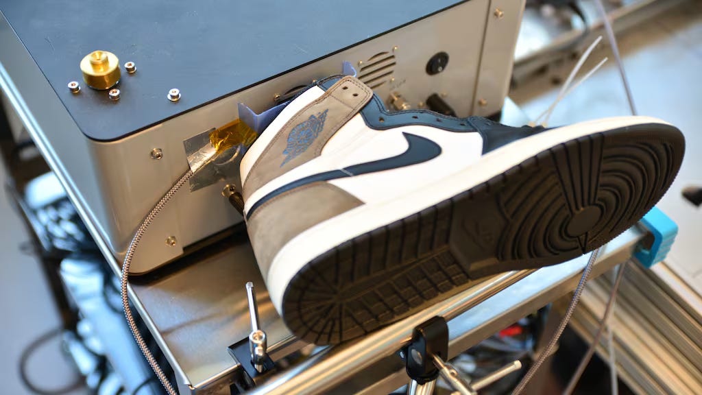 A sensor that looks like a metal box tests a Jordan 1 sneaker.