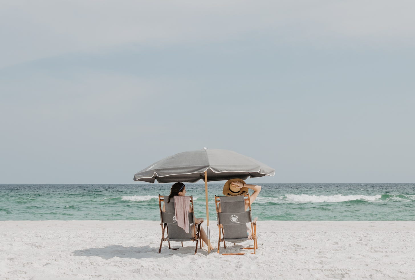 Two women sitting on beach