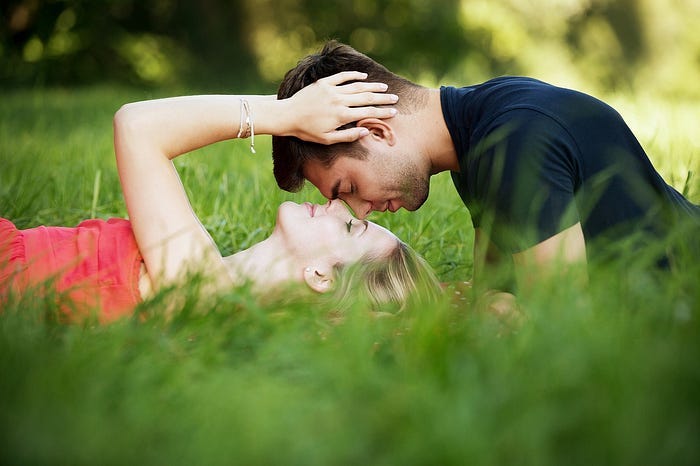 Couple in a field being intimate Couple in a field being intimate