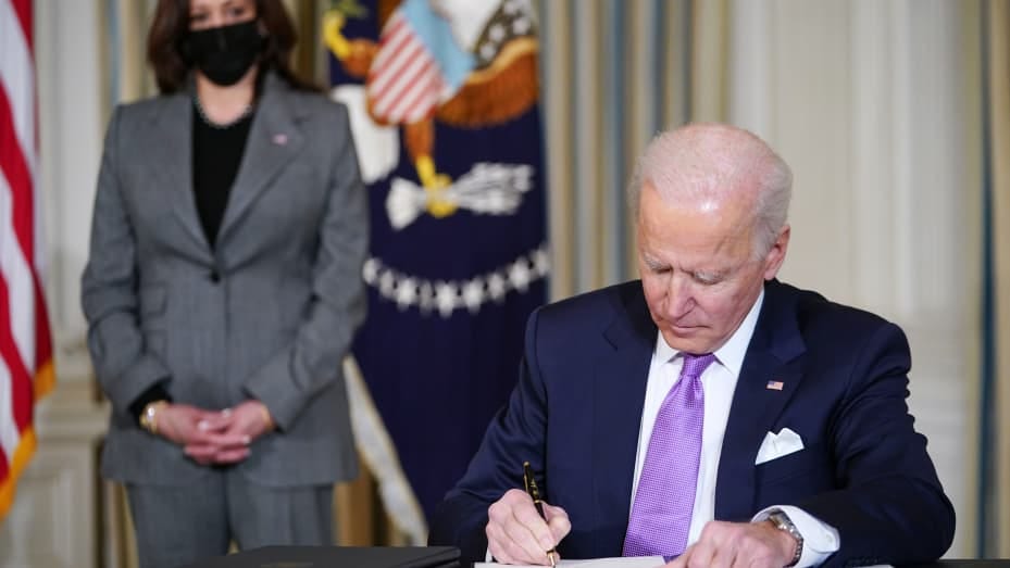 US Vice President Kamala Harris (L) watches as US President Joe Biden signs executive orders after speaking on racial equity in the State Dining Room of the White House in Washington, DC on January 26, 2021.