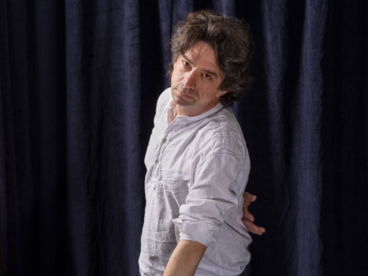 A person in front of a curtain.