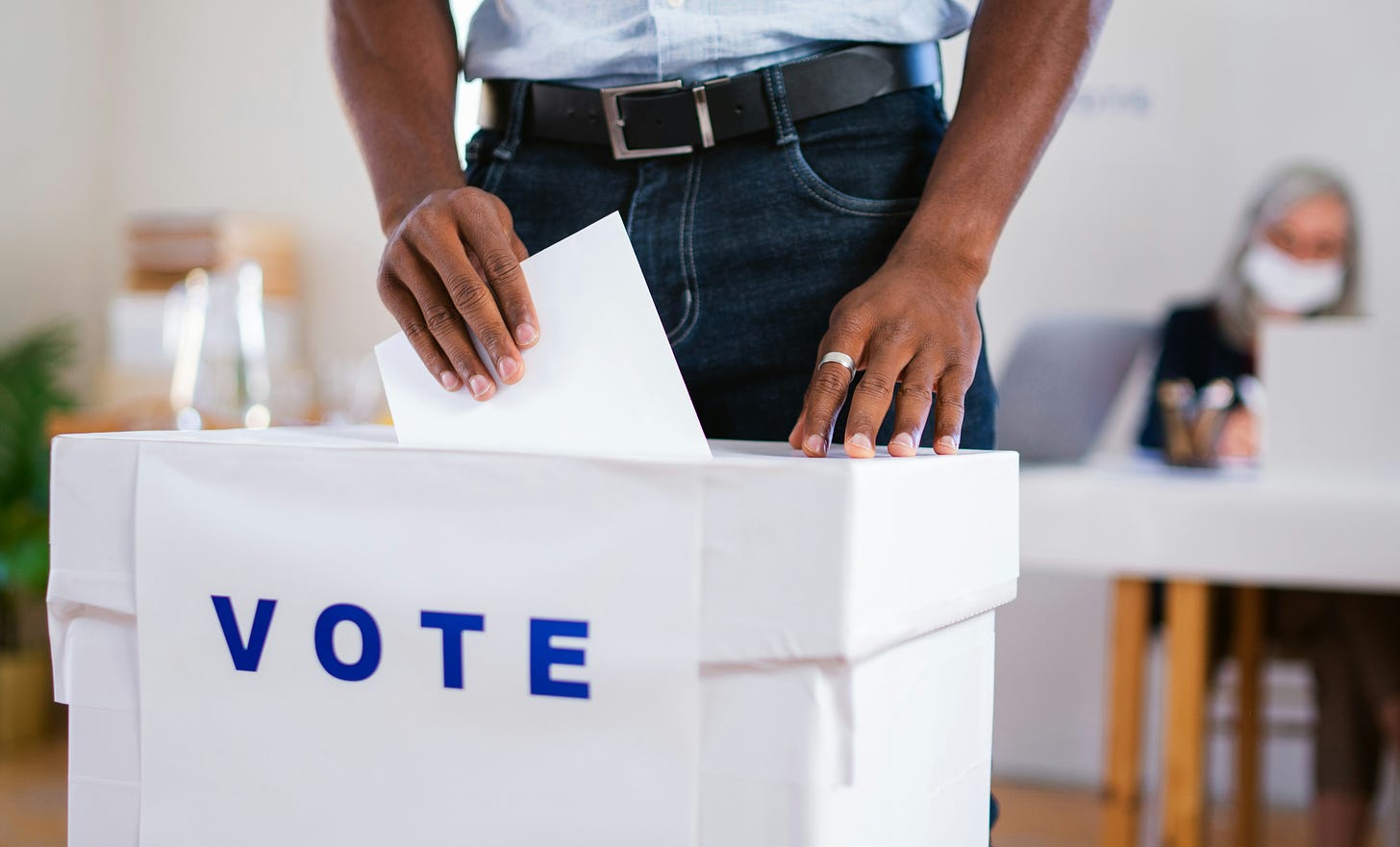 Man putting a ballot into a voting box