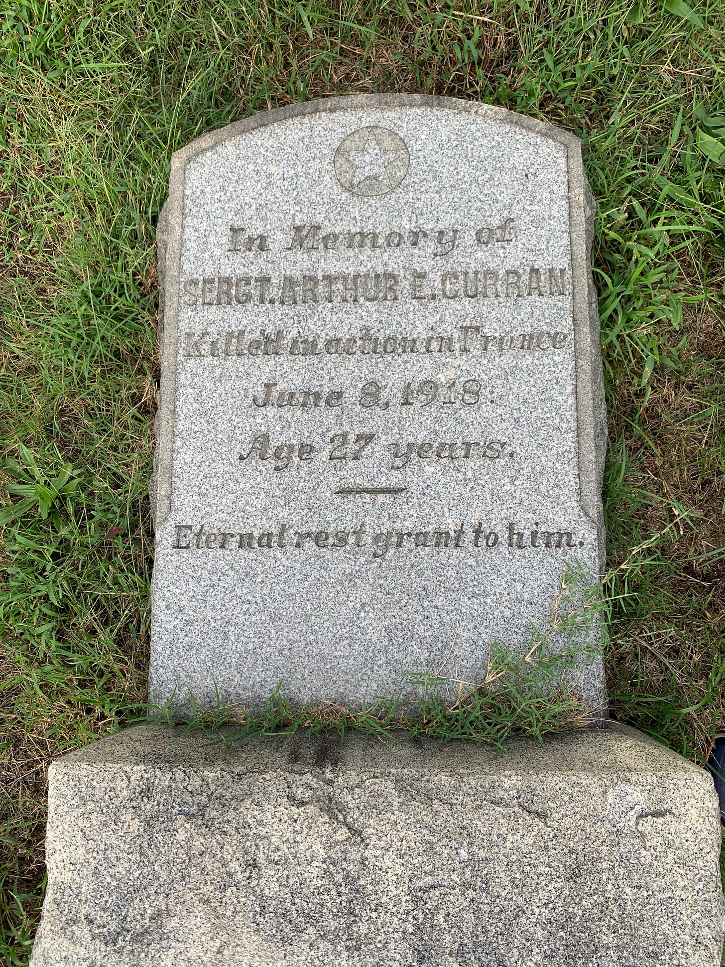 Arthur Curran's granite tombstone laying in the grass