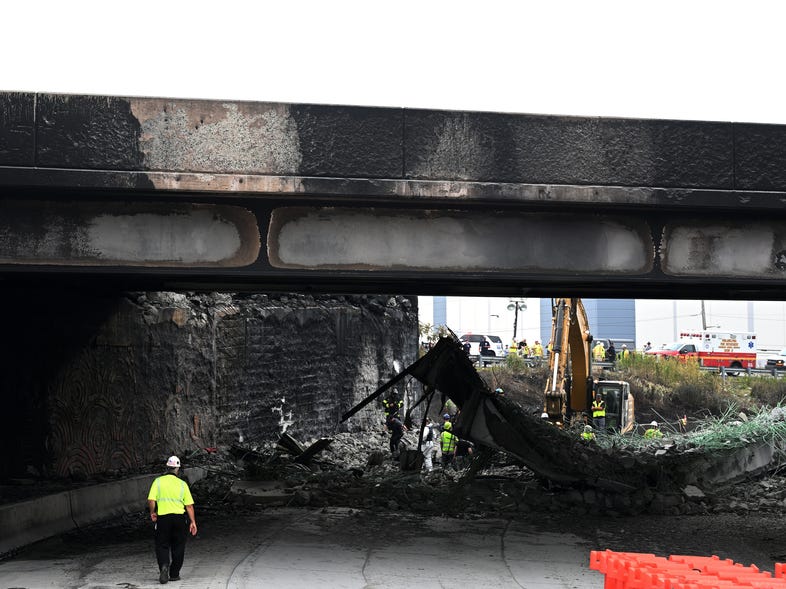 Workers inspect and clear debris on Monday from a section of bridge that collapsed on Interstate 95 in Philadelphia. (Mark Makela/Getty Images)