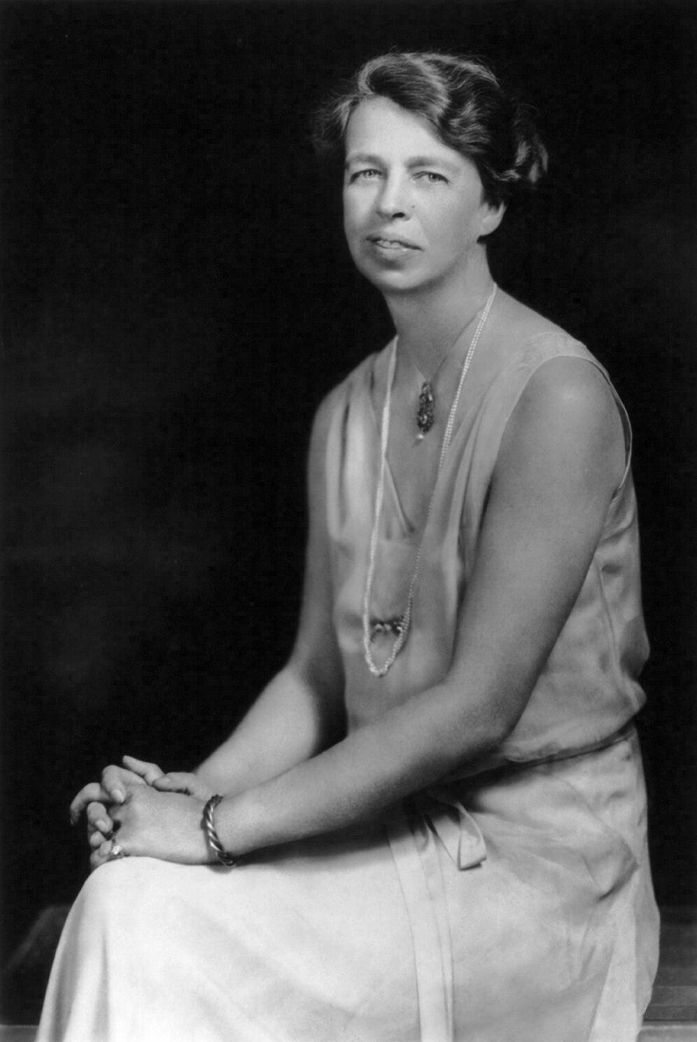 full length portrait of Eleanor Roosevelt in three quarter profile wearing a stylish dress