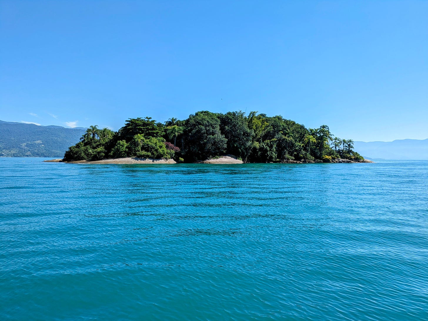 A lush tropical island surrounded by turquoise water