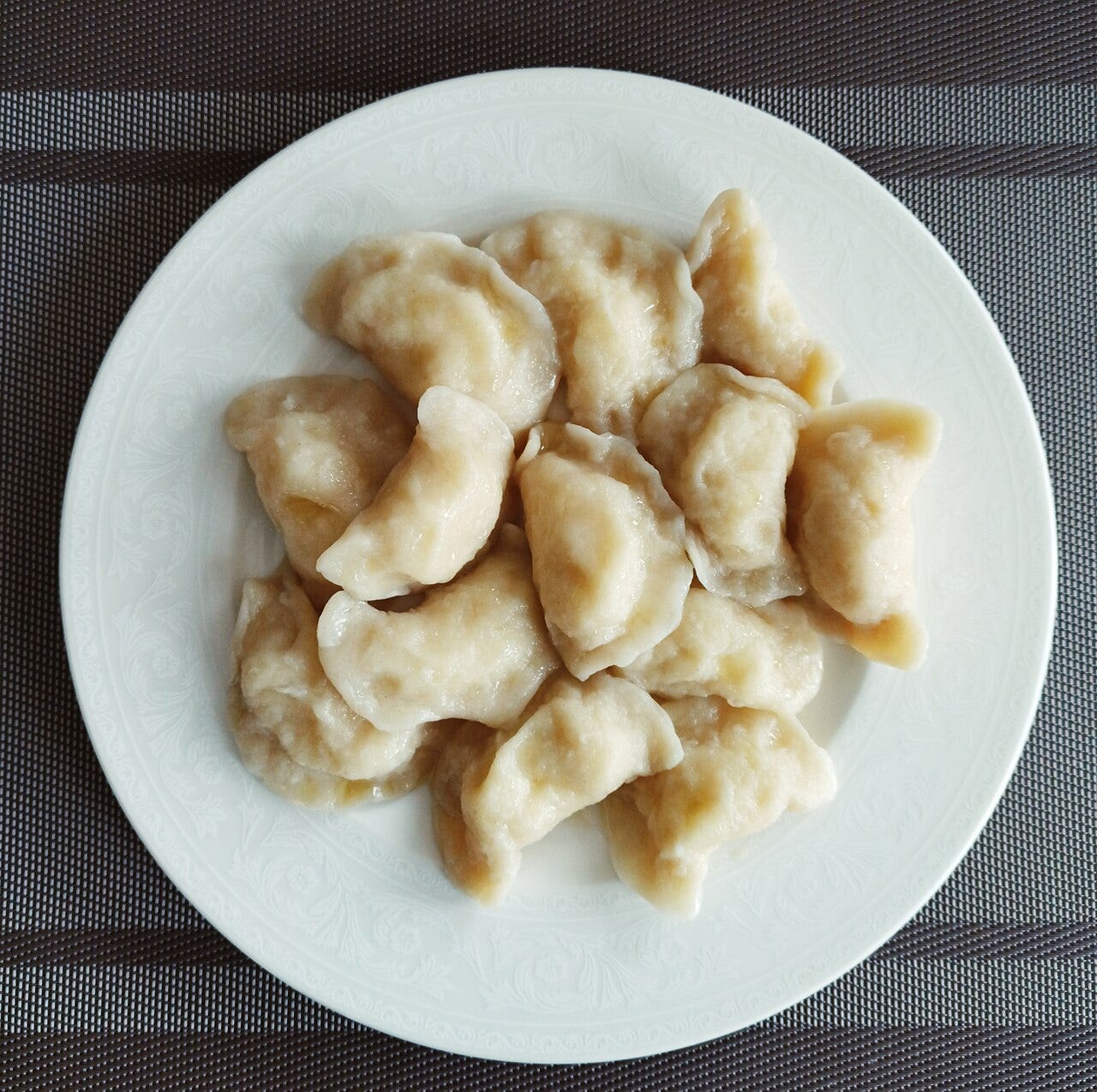 A plate full of pale, but likely very delicious, pierogies.