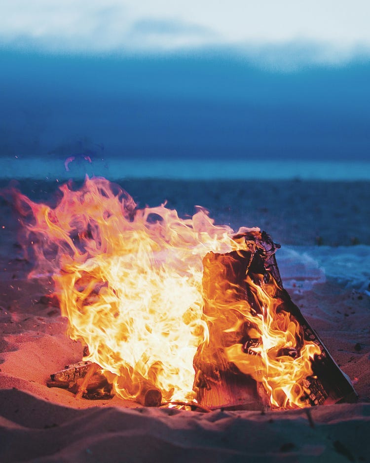 An object burning with flames in the night, with a blue background