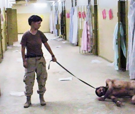 One of the many iconic photographs of the Abu Ghraib prison torture scandal: Lynndie England forcing an inmate, known to the guards as "Gus", to crawl and bark like a dog on a leash.