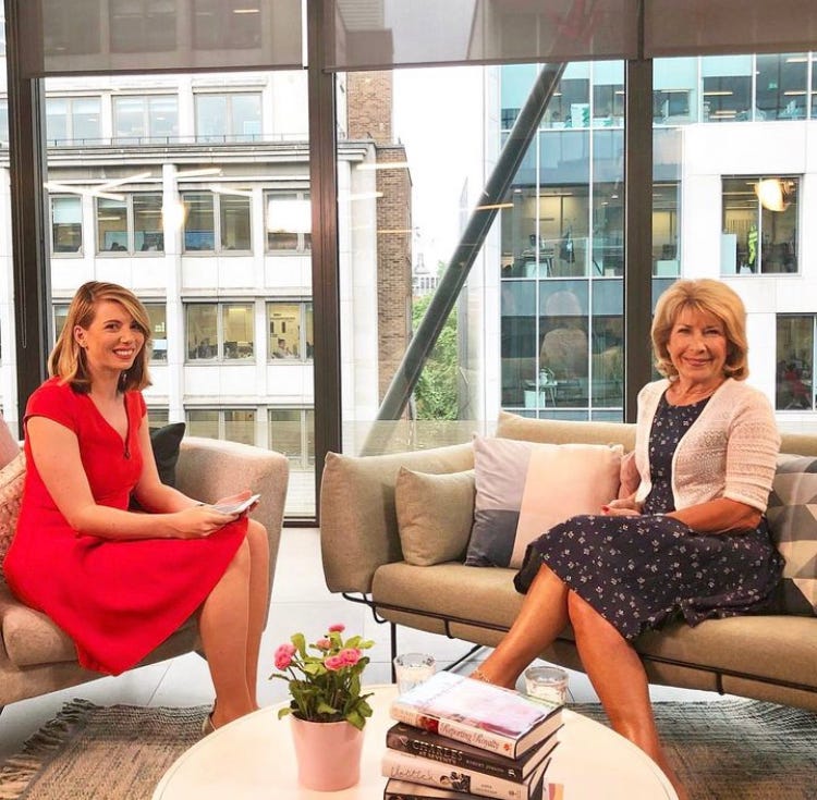 Danielle Stacey interviewing Jennie Bond on pair of cream sofas