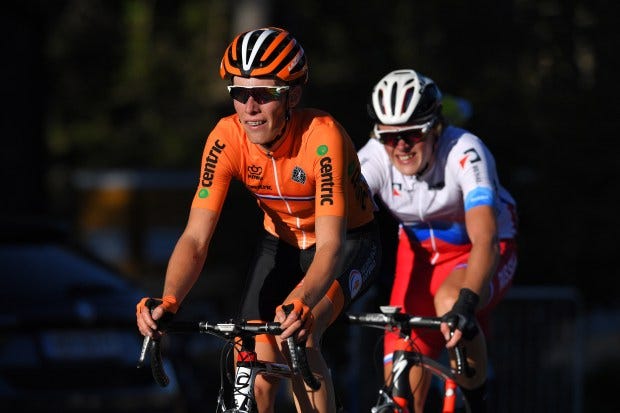 a cyclist wearing an orange jersey that says centric on it