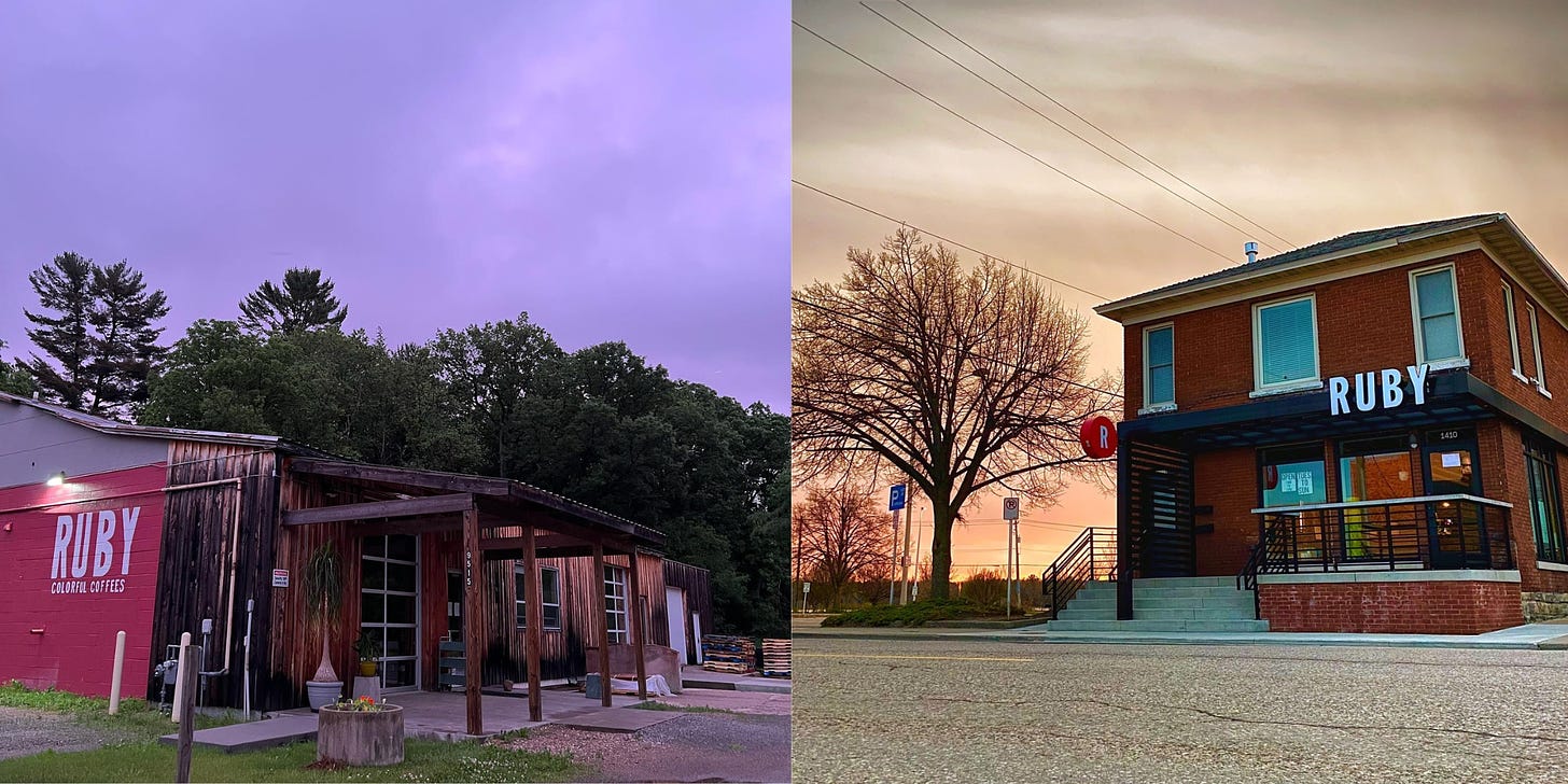 2 images. Left a low-slung overhang over a glass-windowed garage door set in a worn wood exterior of a concrete building is set off by darkened pink and purple clouds at dust. The view is 3/4 angle and leading left off frame the exterior becomes red painted concrete block with the name RUBY Colorful Coffees painted in white on the side under a spotlight. Right: A hero shot from a low angle of the red brick Ruby cafe in front of a sunset. To the left a leaf-less tree stands in silhouette.