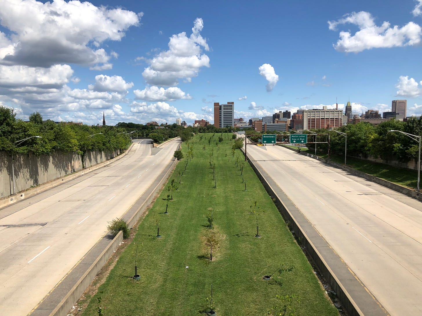 A view of Route 40, a stretch of empty highway known as Baltimore's Highway to Nowhere. The Baltimore skyline is visible in the distance.