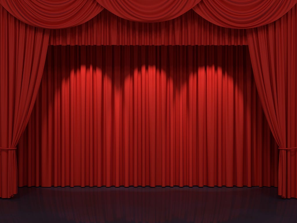 Red curtains framing an empty stage