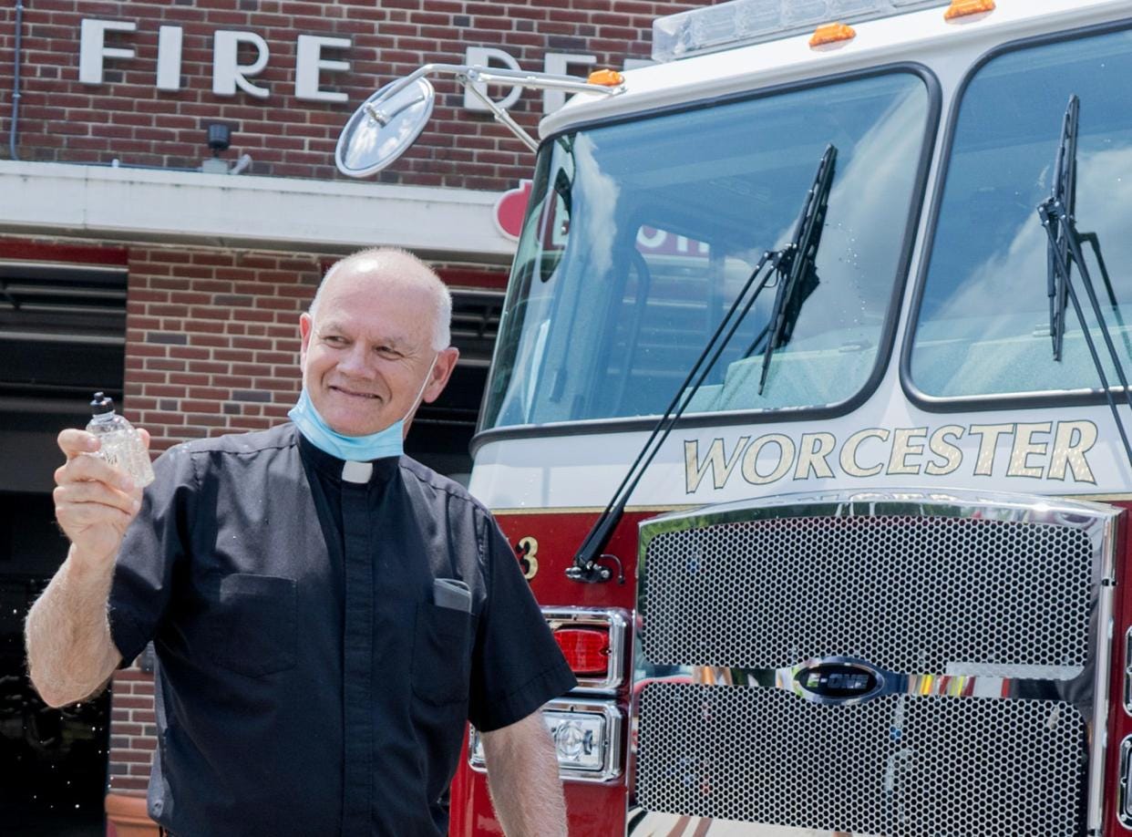 Rev. Walter Riley, Worcester Fire Department chaplain, blesses the new Engine 3 during a ceremony July 9, 2020.