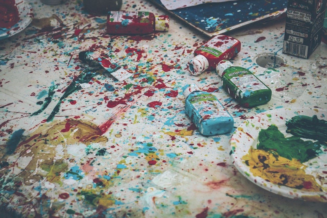 assorted-color bottles on white surface with paint scribbles assorted-color bottles on white surface with paint scribbles