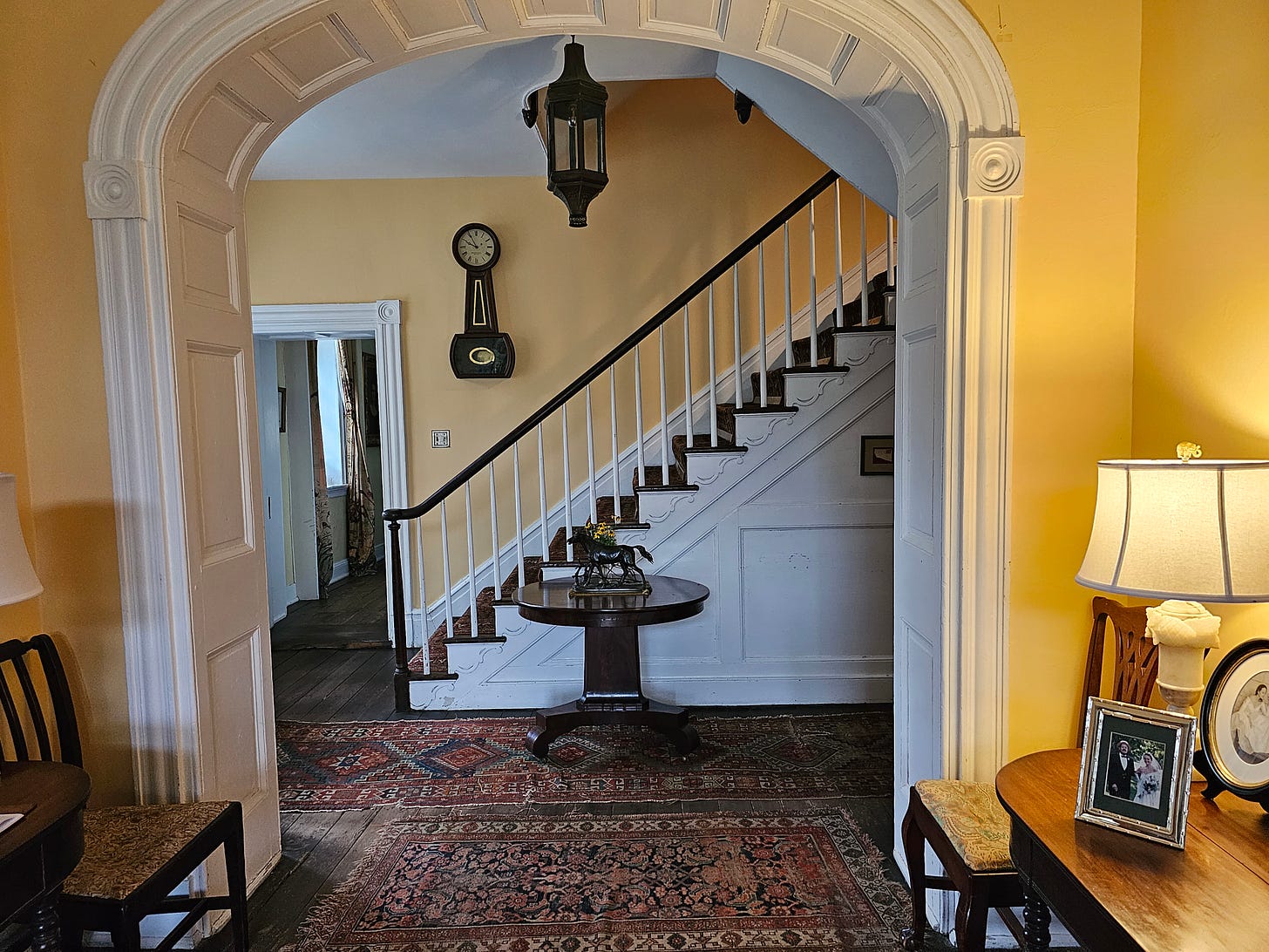 an arched doorway to the stairway, with yellow paint on the walls.