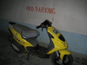 Scooter parked by No Parking sign