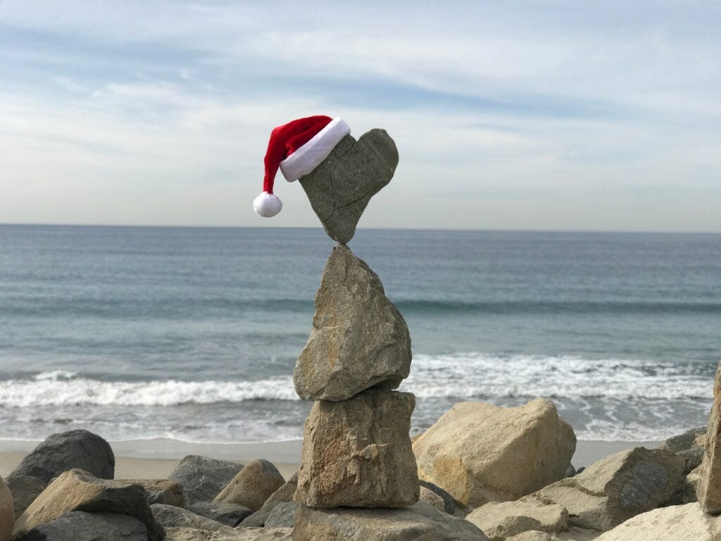 Holiday Santa hat balanced on a rocky beach