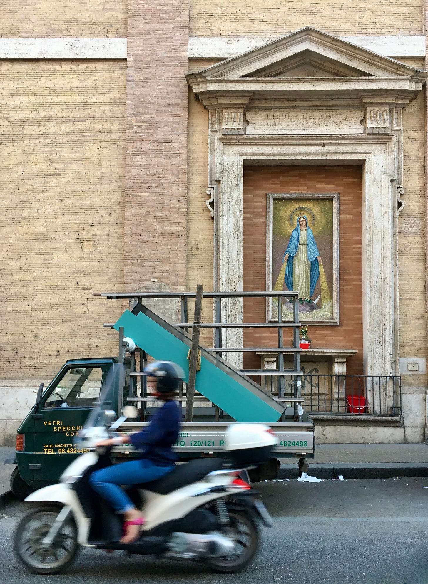 motoring flying past the glass truck in front of the mosaic madonna on via Serpenti, Rome