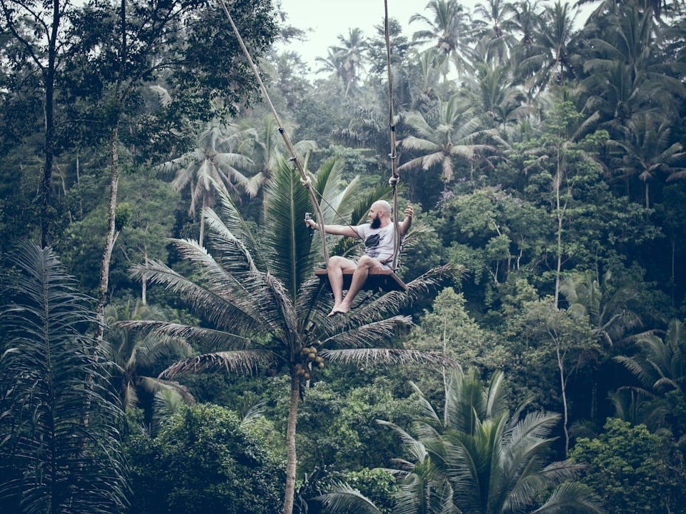 man swinging on brown swing