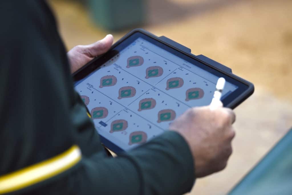 A member of the Oakland Athletics coaching staff uses a tablet to look at data on Texas Rangers&#039; hitters in the second inning of a baseball game, Saturday, April 8, 2017, in Arlington, Texas. (AP Photo/Jeffrey McWhorter)