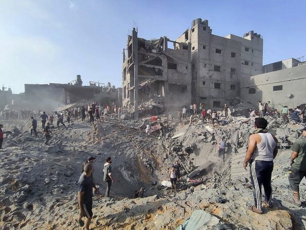 Palestinians inspect the damage of buildings destroyed by Israeli airstrikes.