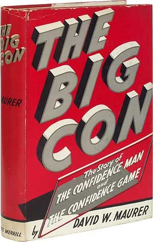 A red hardback book with the title "The Big Con" in large 3D lettering on its cover.