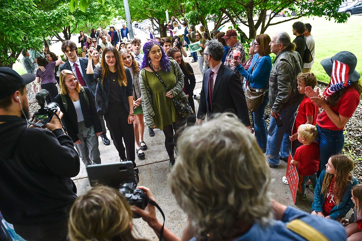 The young plaintiffs being photgraphed by the media as they walk towards the Lewis and Clark County Courthouse for trial hearings.