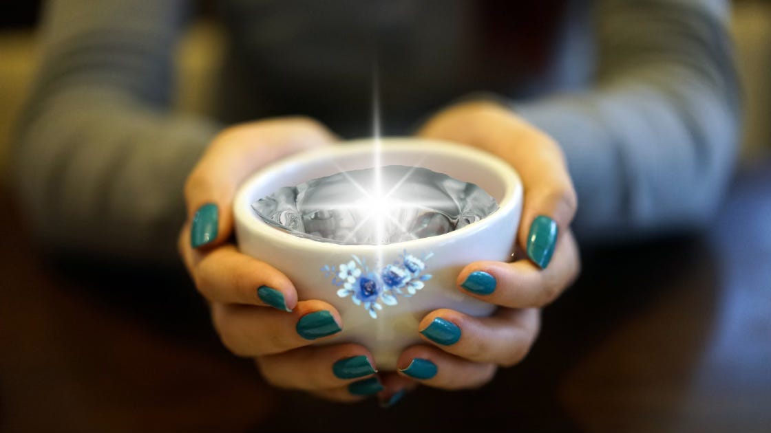 Feminine hands with bright teal nails cradle a white cup with blue flowers. Within shimmers the sweetest water.