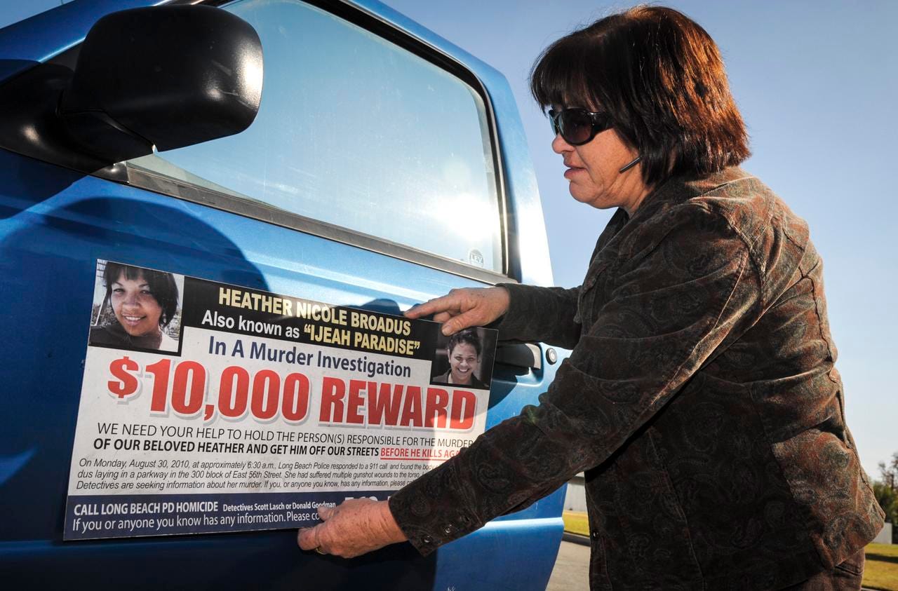 Nancy Smith places a magnetic poster asking for information related to the death of her daughter, Heather Broadus.