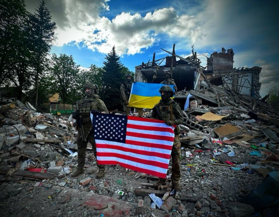 Ukrainian soldiers in front of a destroyed school holdings the Ukrainian and US flags