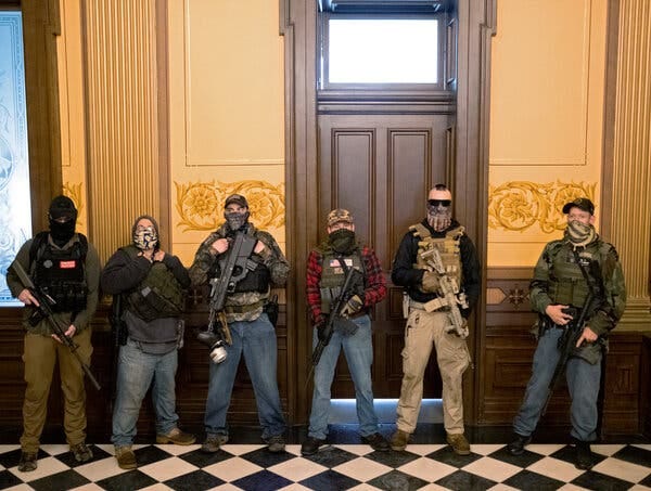 A militia group stands in front of the governor’s office after armed protesters occupied the State Capitol building during a vote to approve the extension of Gov. Gretchen Whitmer’s stay-at-home order in Lansing, Mich., in April.